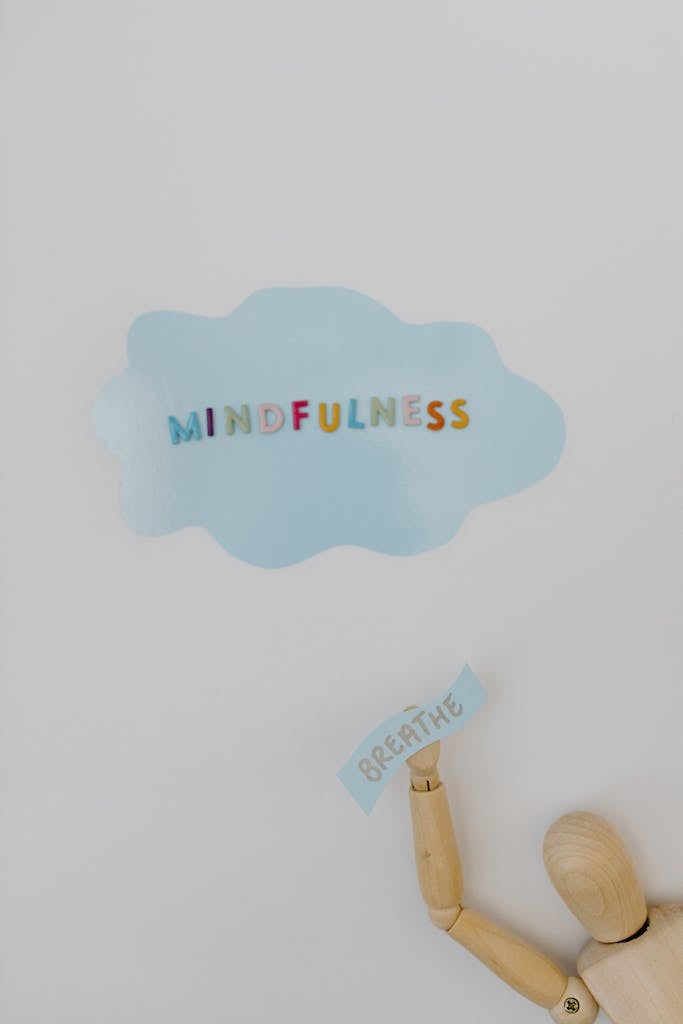 Wooden Figurine and Mindfulness Word on White Background