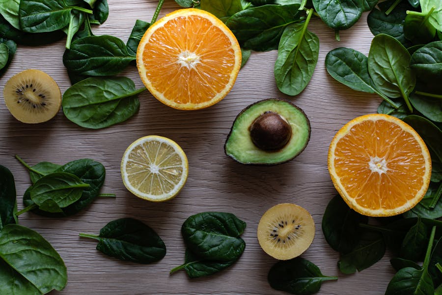 Half Sliced Fruits with Scattered Spinach Leaves